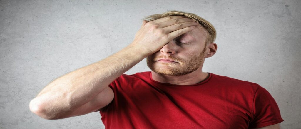 Picture of man holding his forehead in pain associated with blog on measuring pain