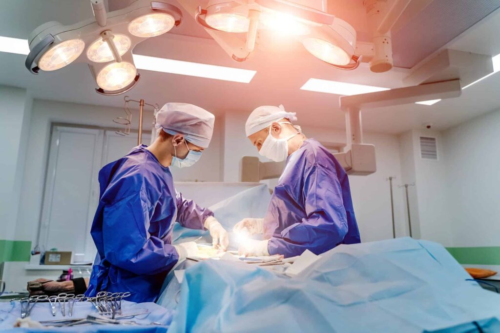 Two surgeons working on a patient carefully to avoid any medical malpractice where the patient would need an attorney.