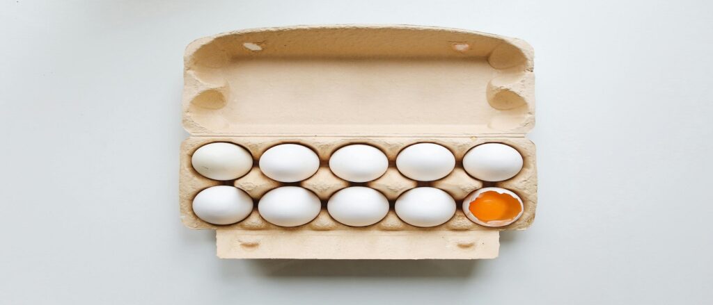 Picture of dozen eggs with one broken suggesting a defect associated with blog on personal injury product liability