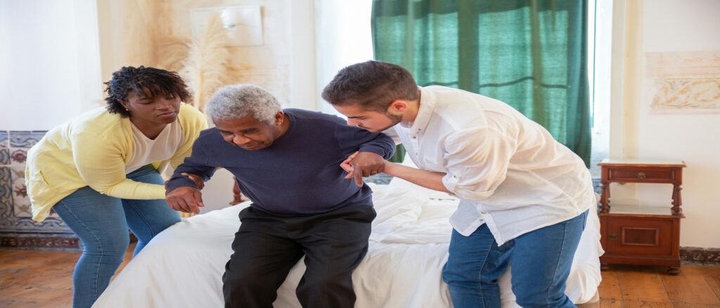 Picture of two attendants helping senior citizen associated with blog on nursing home malpractice