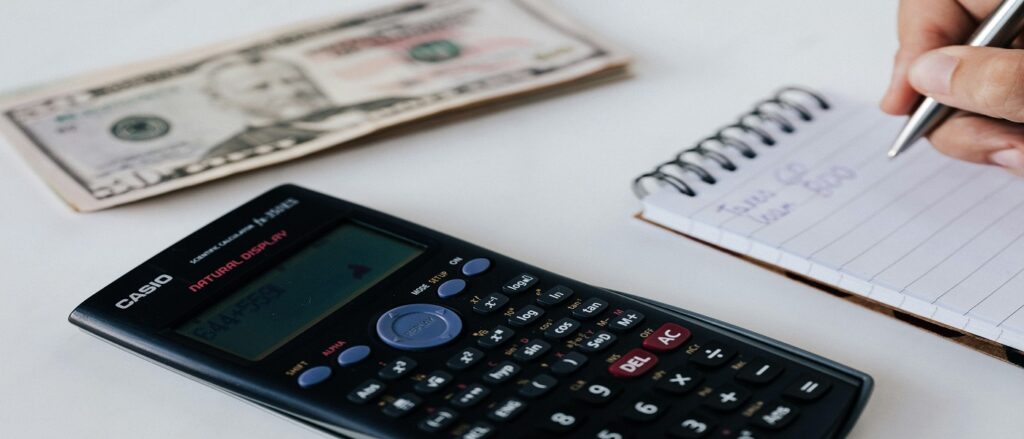 Picture of calculator and money associated with blog on present value calculations in personal injury cases