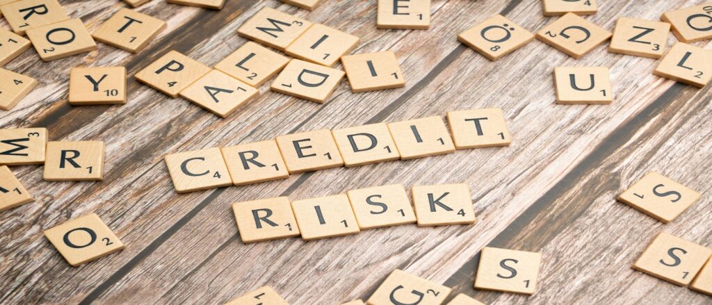 Picture of scrabble board with the words credit risk associated with blog on personal injury default