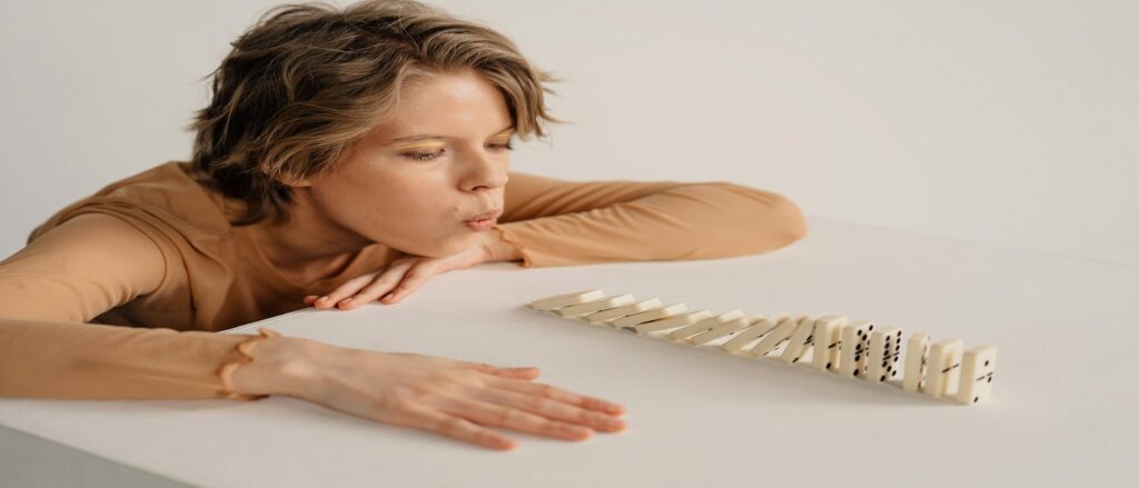 Picture of person causing dominoes to fall associated with blog on legal malpractice causation damages
