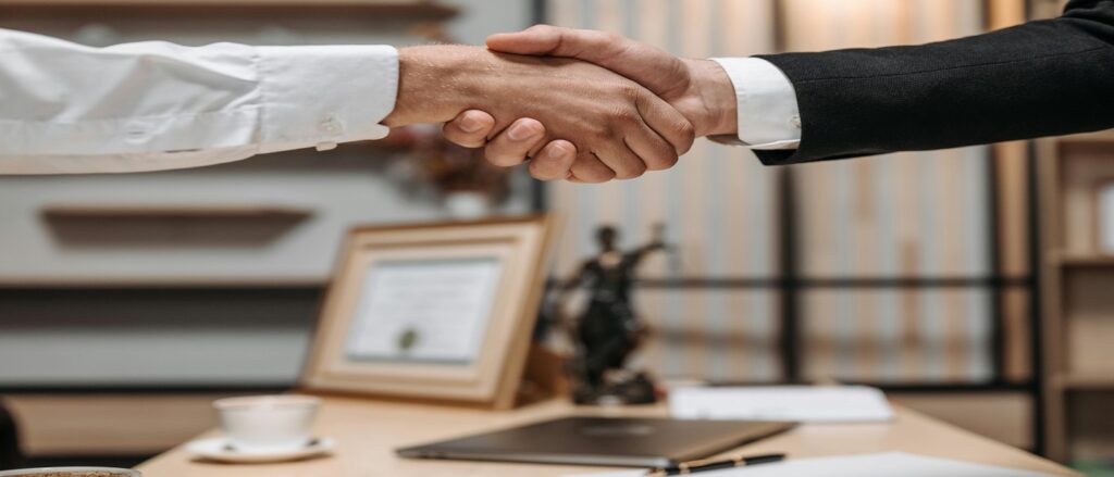 Picture of attorney and client shaking hands associated with blog on legal malpractice proving relationship