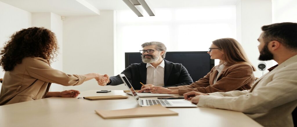Picture of people around a conference table trying to settle a matter associated with blog on car accident underinsured motorist coverage settling